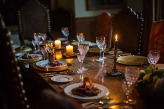 DInning table decorated with candles, food and drinks