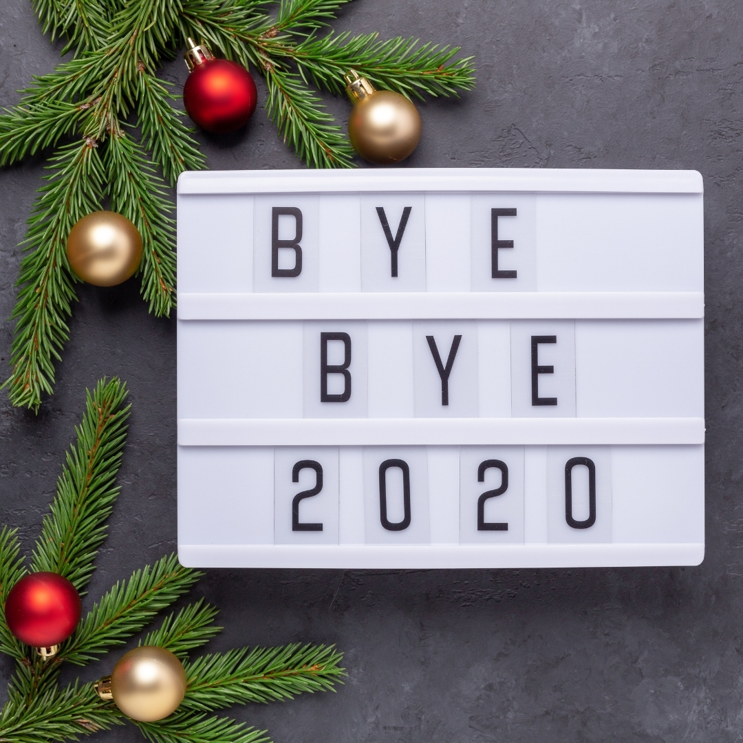 A light box with "bye bye 2020" in letters, baubles and christmas tree brnaches surrounding