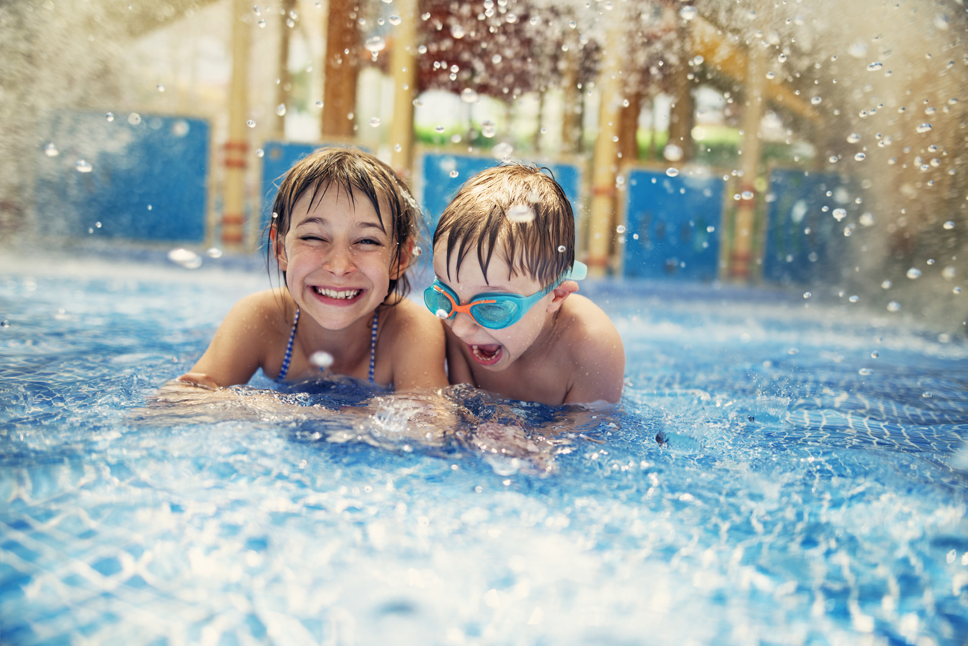Two children laughing in a swimming pool   