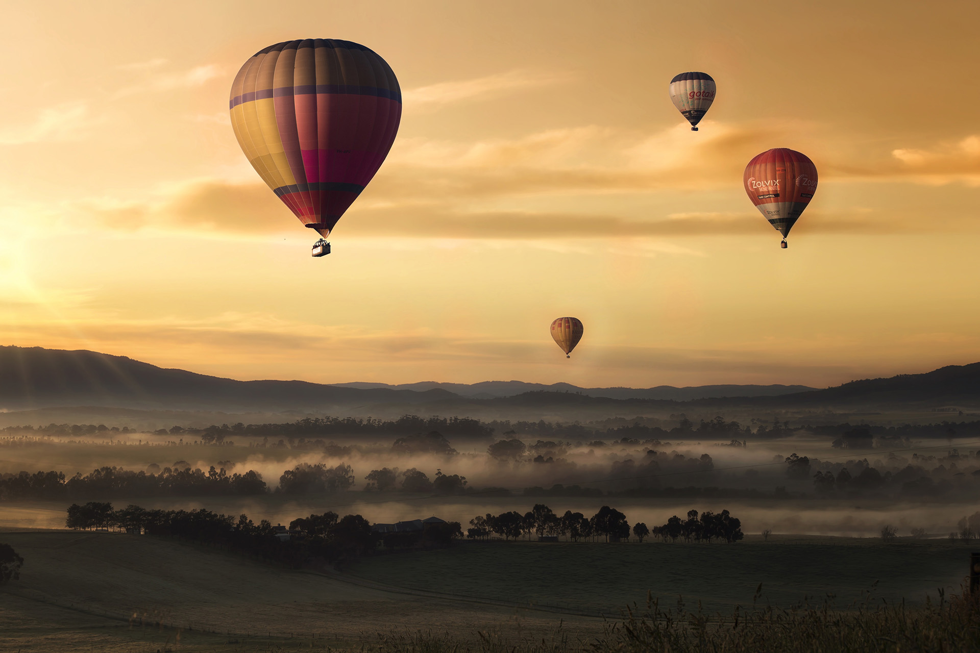Four hot air balloons flying at dusk   