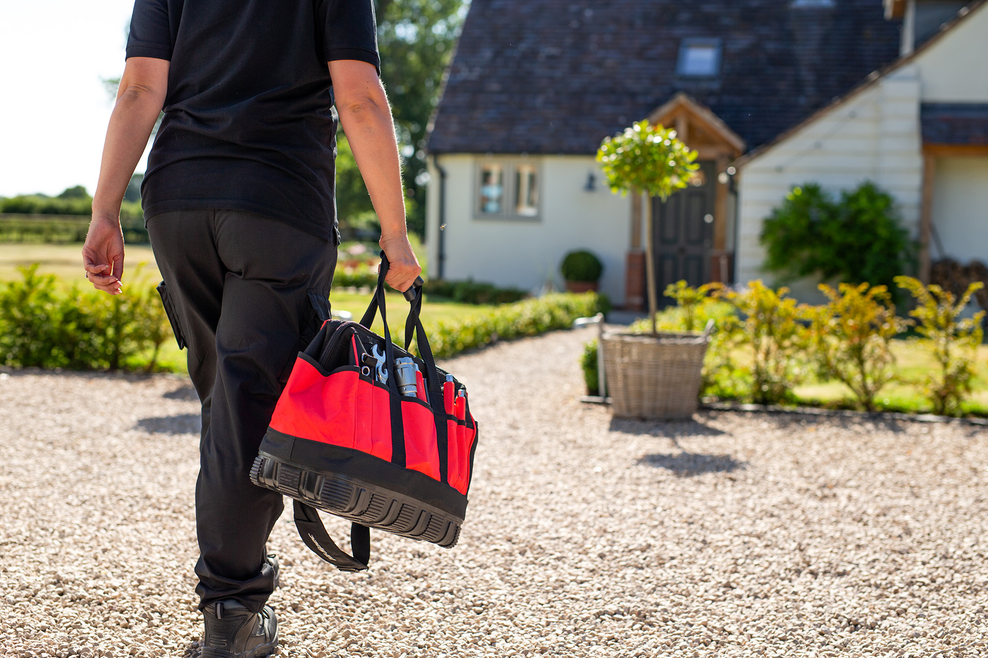 A Calor employee holding a tool bag and walking towards a Calor customer’s house