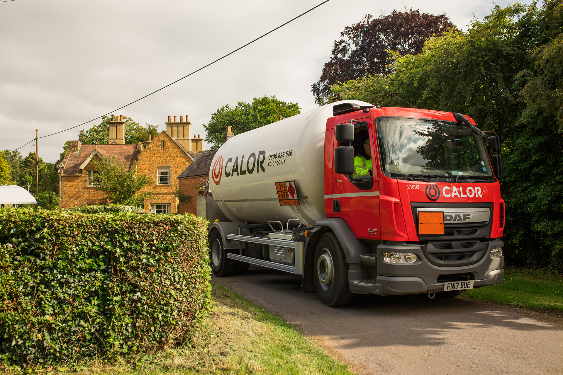 A Calor lorry driving on a narrow road in a rural village