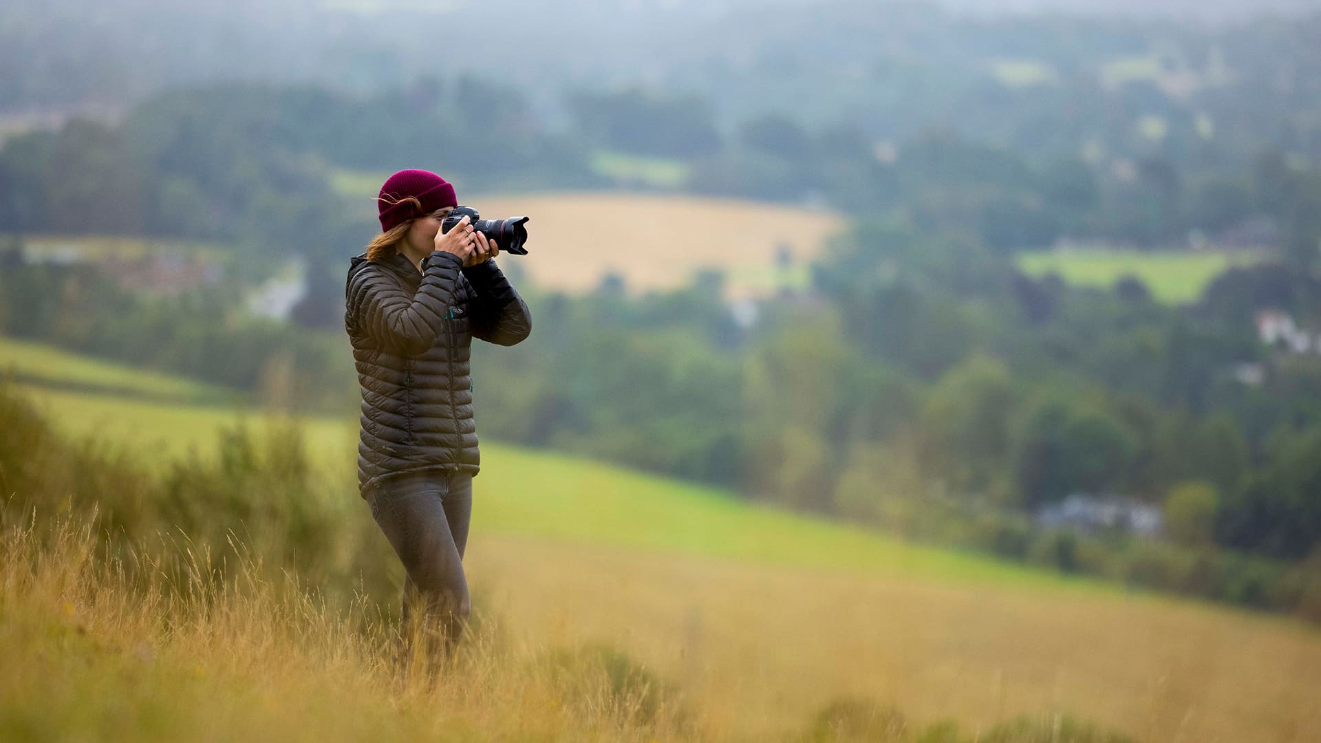 A woman taking pictures in the countryside